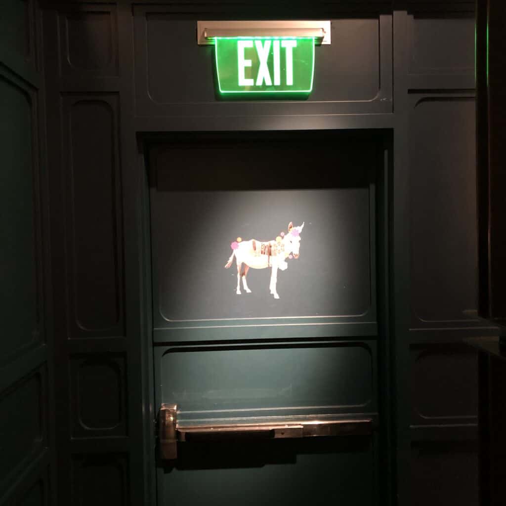 Green door with white donkey painted on it