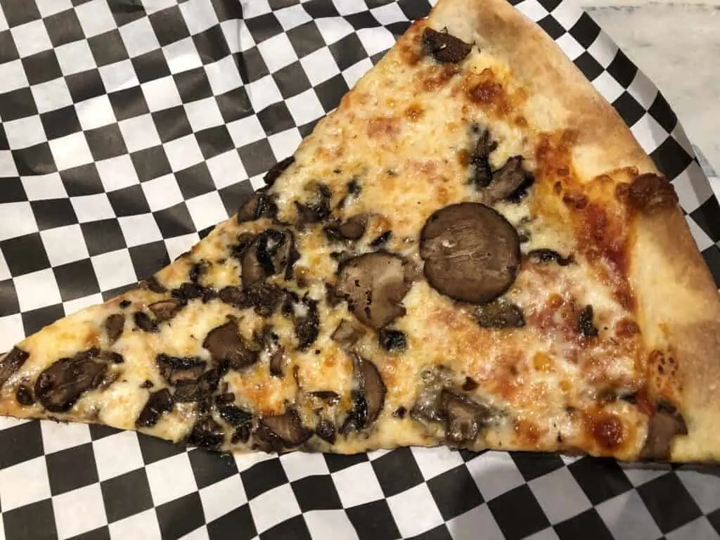 Slice of mushroom and cheese pizza from Secret Pizza at Cosmopolitan