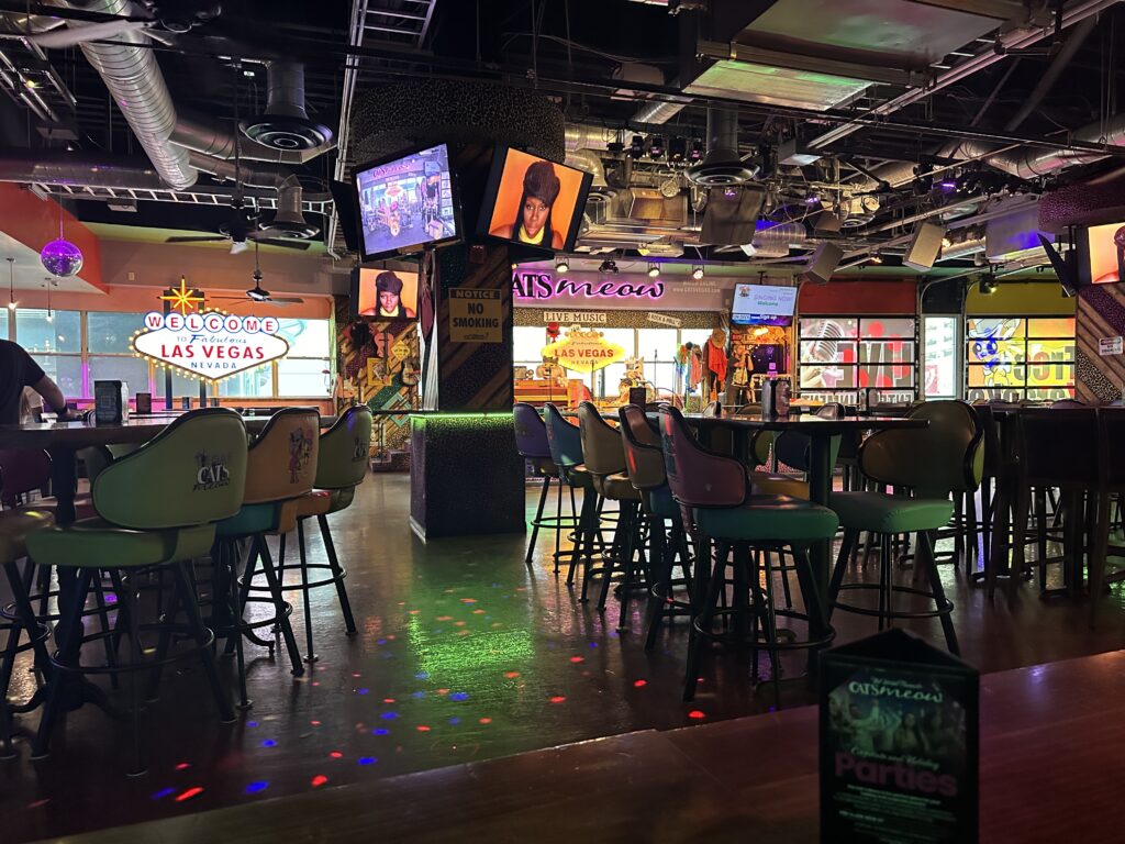 Inside Cat's Meow, with table seating and a stage in the background.