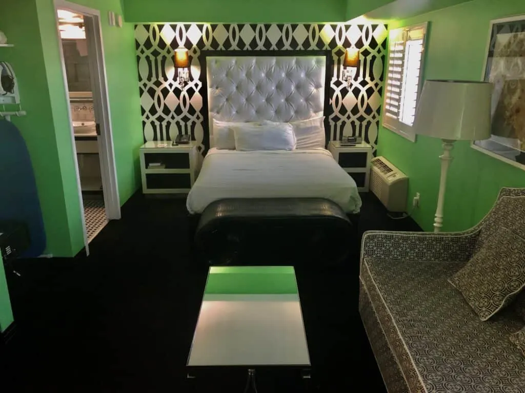 Queen bed with coffee table and couch in the foreground. 