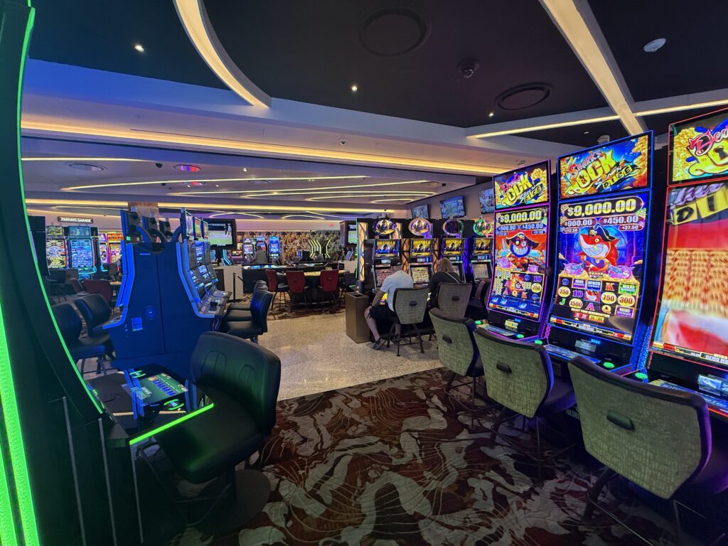 A portion of the casino floor, lined with slot machines. 
