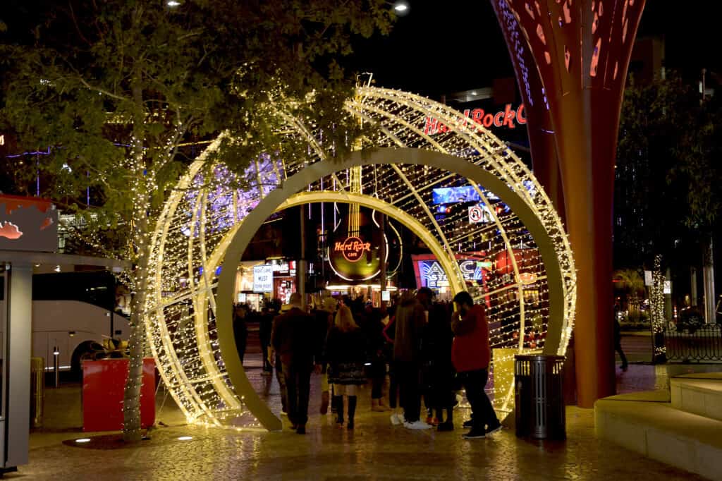 People walking through an illuminated ornament