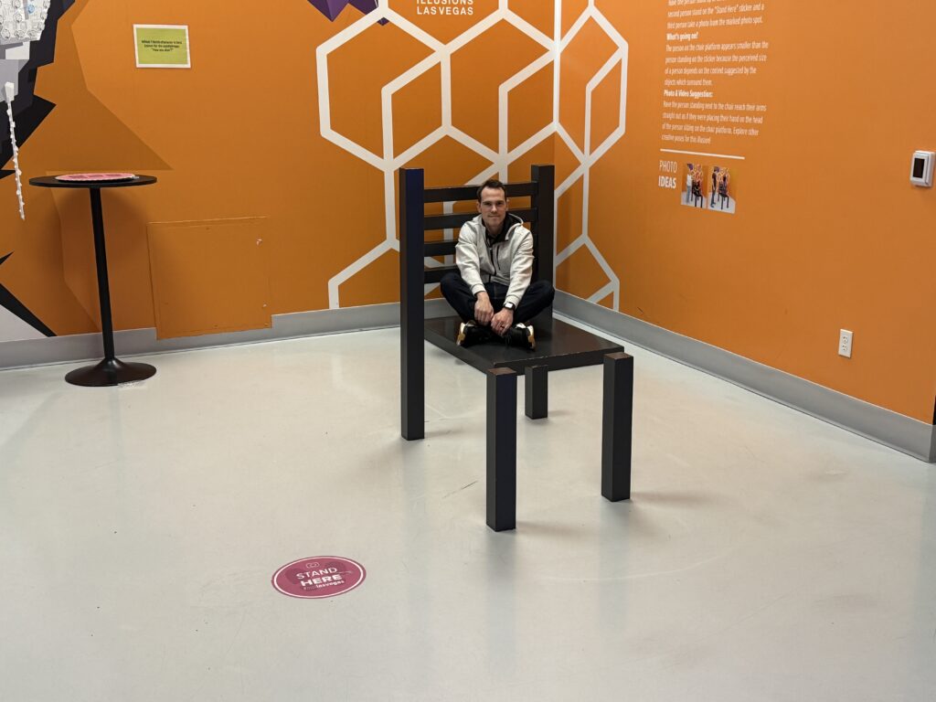 My brother, sitting in on an illusion that makes it appear he is sitting in a chair.