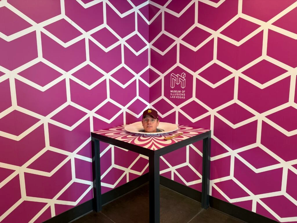 An illusion that makes it appear as if my head is on a platter atop a table.