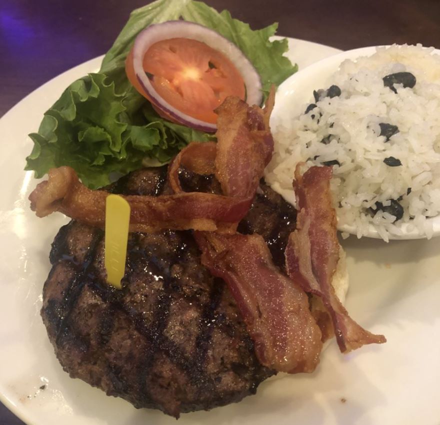 Hamburger with lettuce and tomato with rice on the side