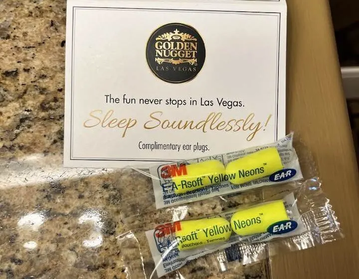2 sets of neon yellow earplugs sit on an endtable next to the bed at Golden Nugget.