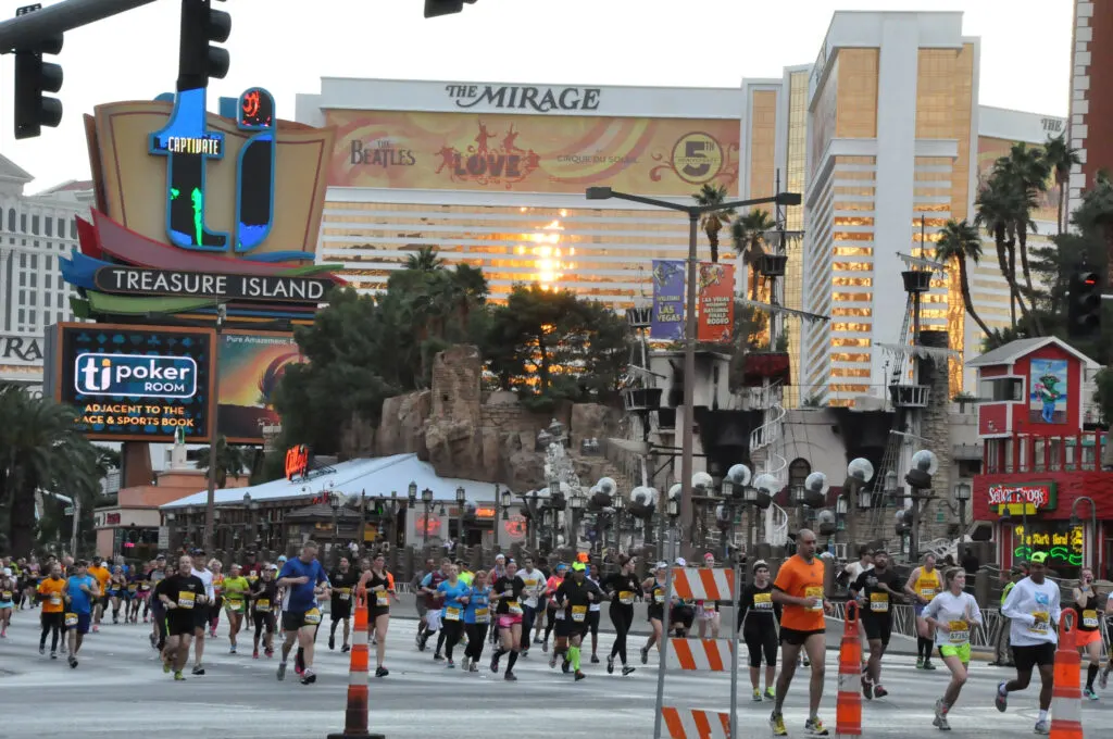 Runners running down the Las Vegas Strip with Mirage in the background