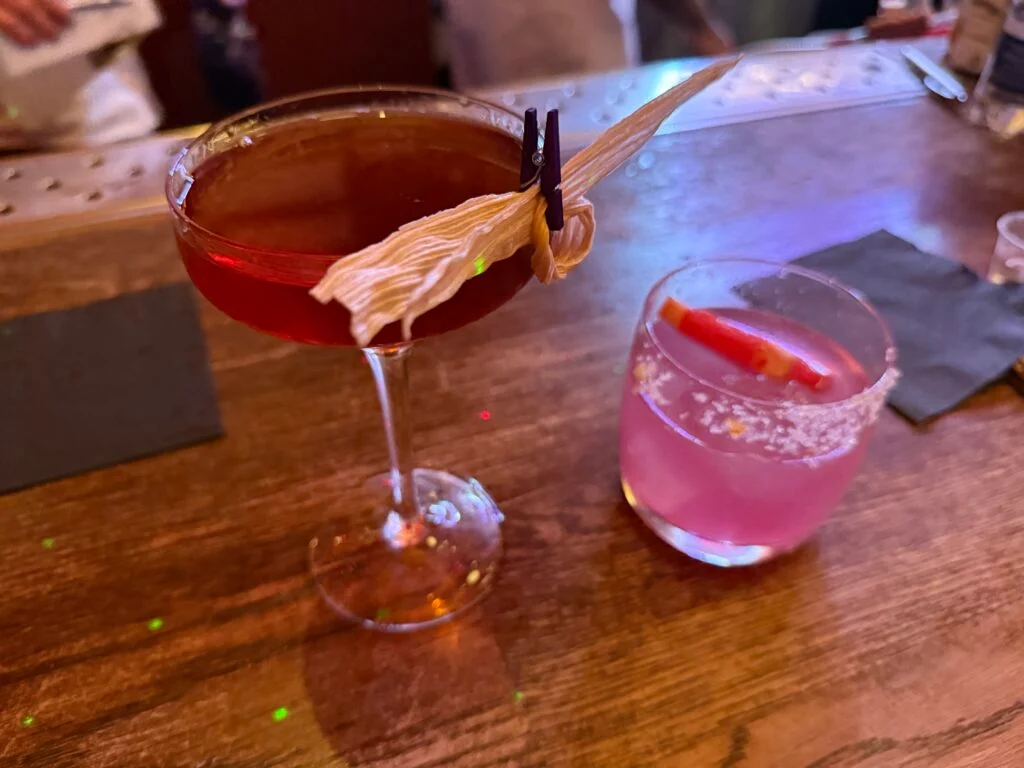 Two fancy drinks, one pink, one brown. 