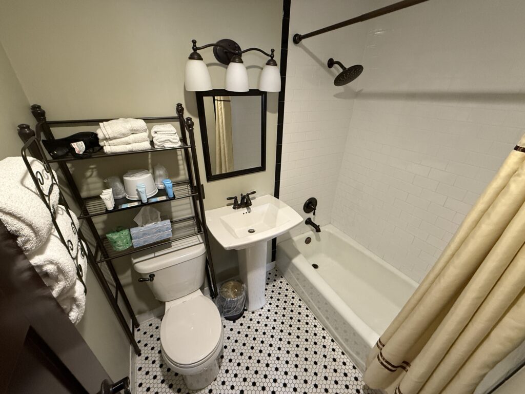A very small bathroom with a toilet, sink, and tub/shower combo. 