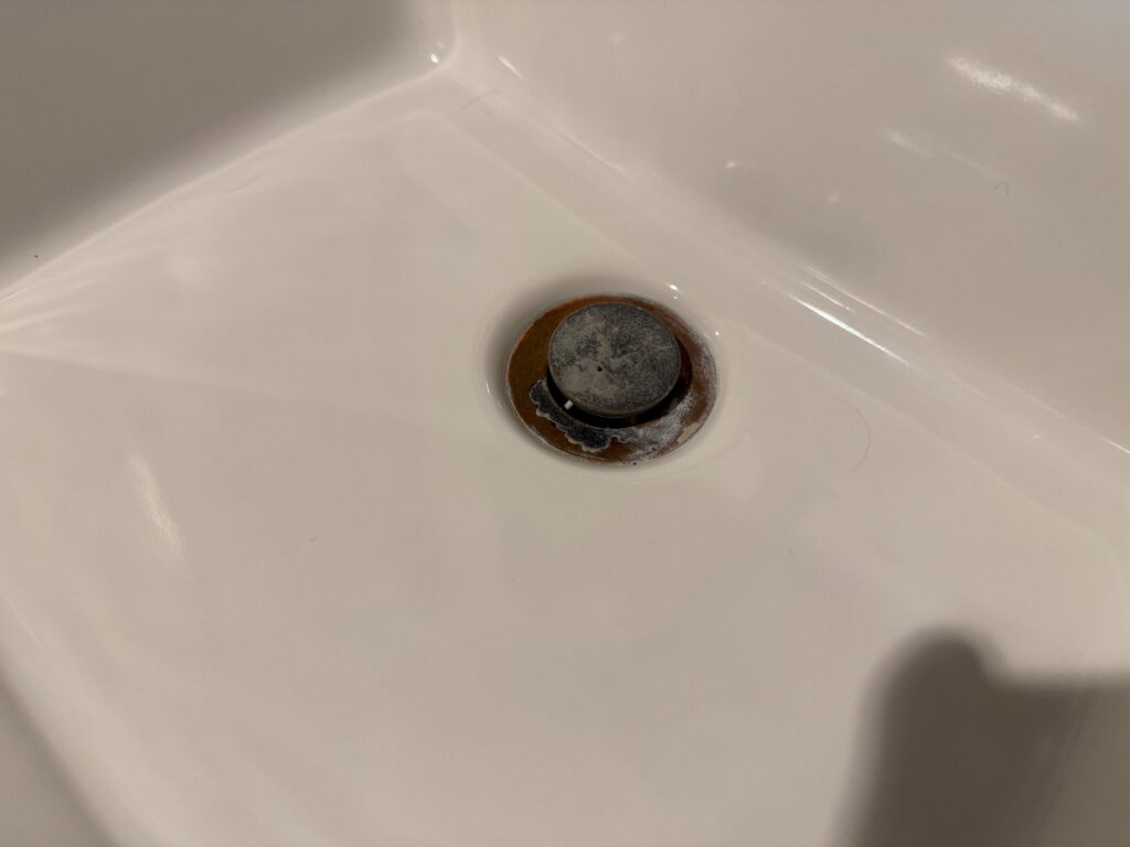 A calcium or lime encrusted sink drain. 
