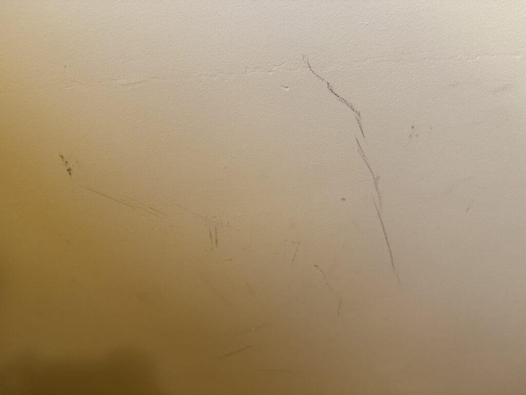 Black scuffs on a yellow wall. 