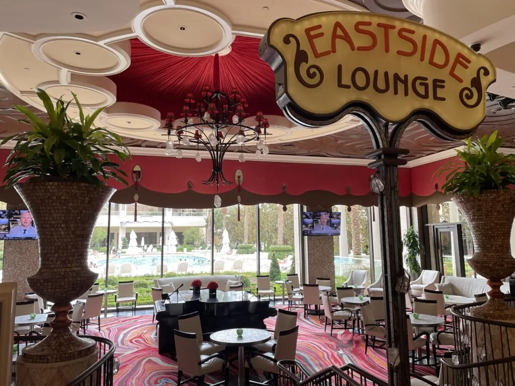 Entrance to Eastside Lounge at Encore with 2 pianos sitting in the middle of the lounge and Encore's pool in the background viewable through the windows