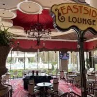 Entrance to Eastside Lounge at Encore with 2 pianos sitting in the middle of the lounge and Encore's pool in the background viewable through the windows