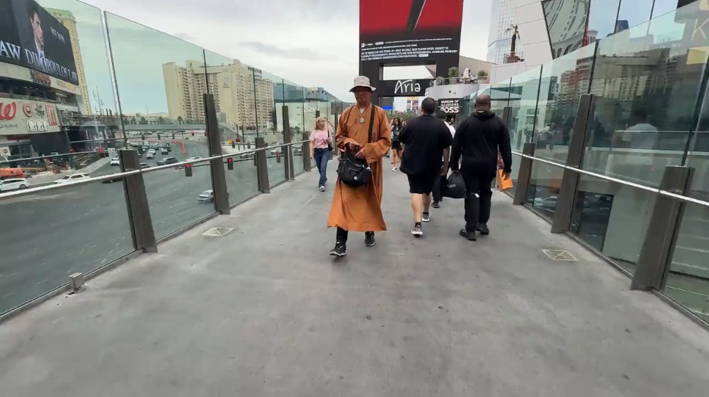 A "monk" handing out bracelets on a Strip pedestrian bridge.
