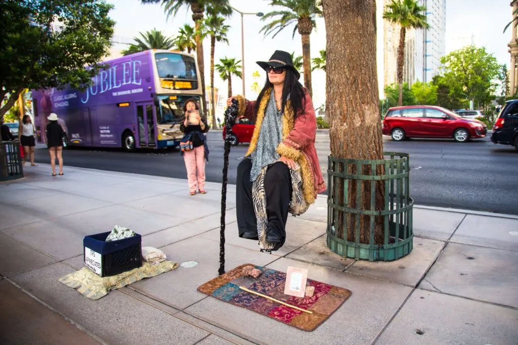 A street performer along the Strip appears to be levatating about 3 feet off the ground. 