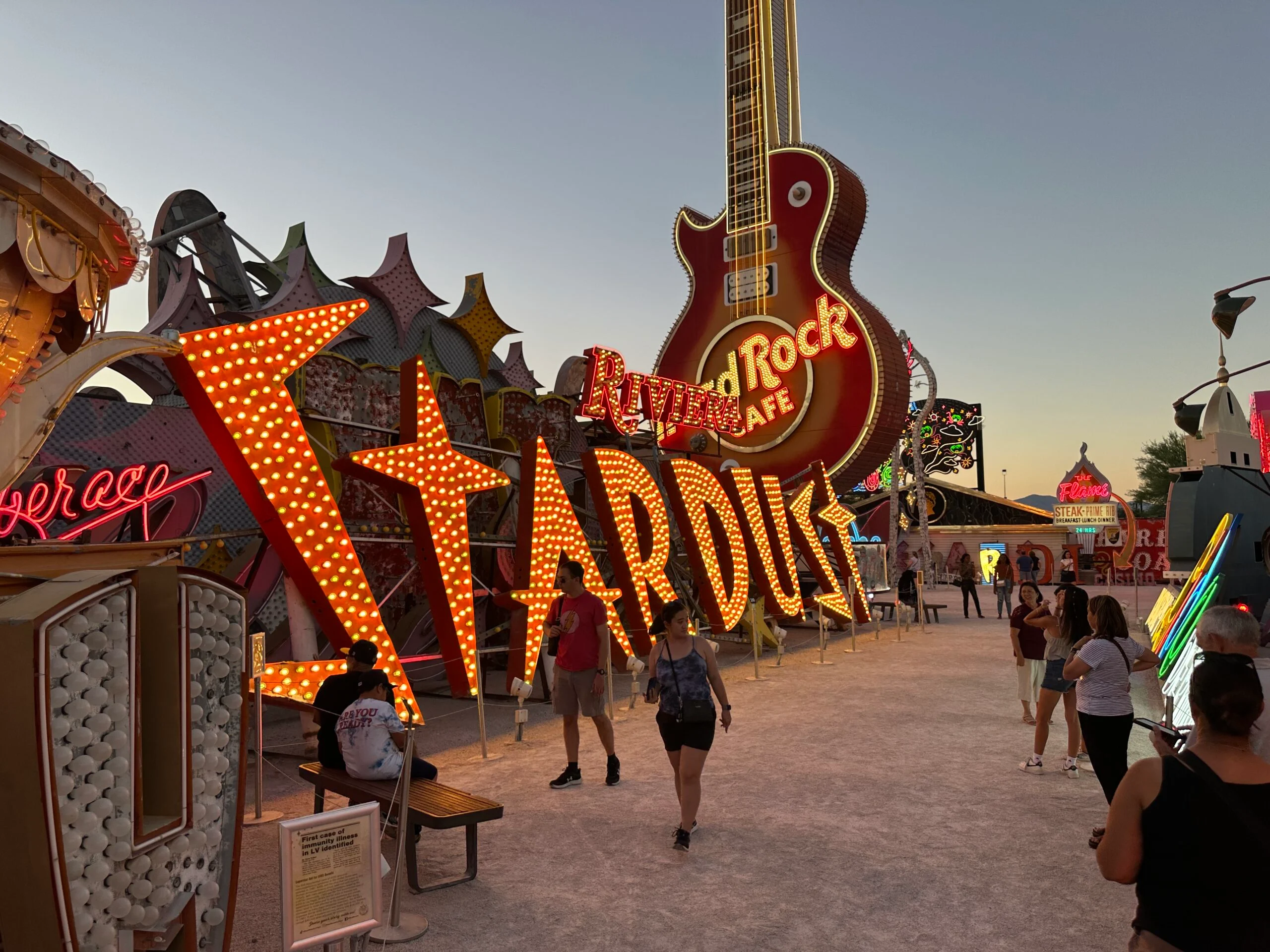 A sign for STARDUST illuminated at dusk.