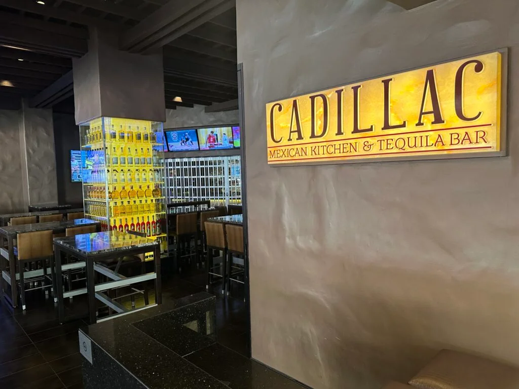 Exterior of Cadillac Mexican Kitchen. Inside, you can see a pillar surrounded by illuminated bottles of liquor.