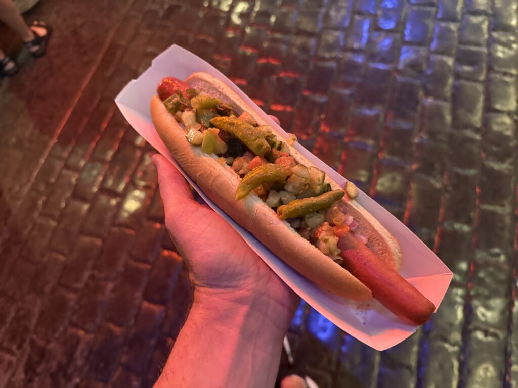 A chicago style dog, piled with veggies in my hand. 