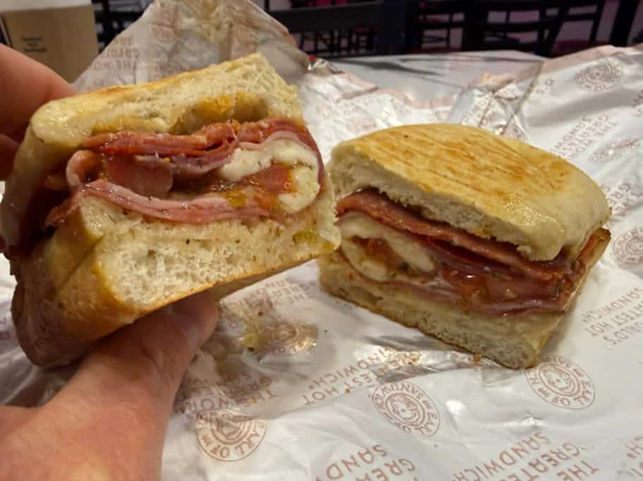 An italian sub, posed so that you can see the meat piled inside.