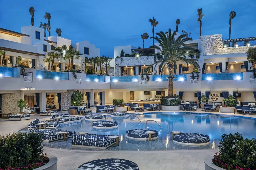 Pool with partially submerged daybeds and cabanas surrounding it