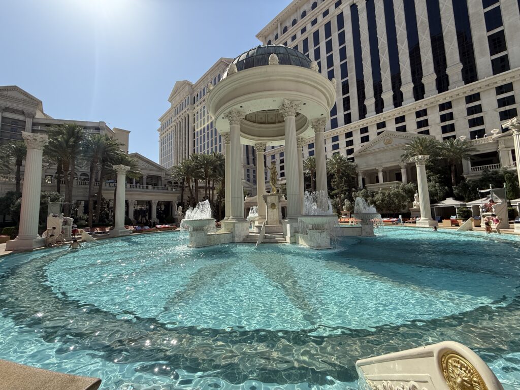 A pool with a roman column in the middle of it.