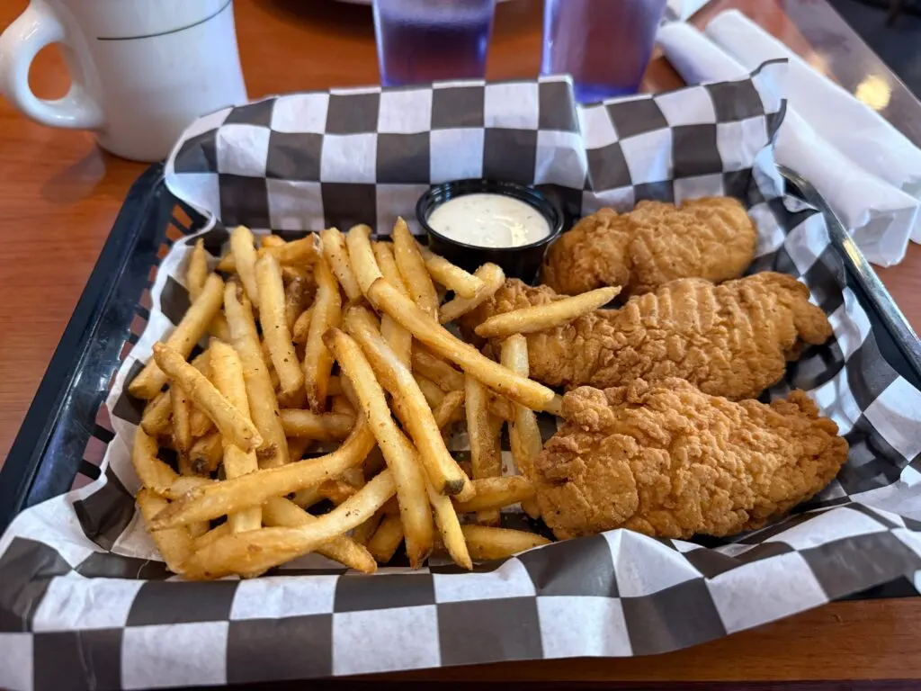 A basket of chicken fingers and french fries. 