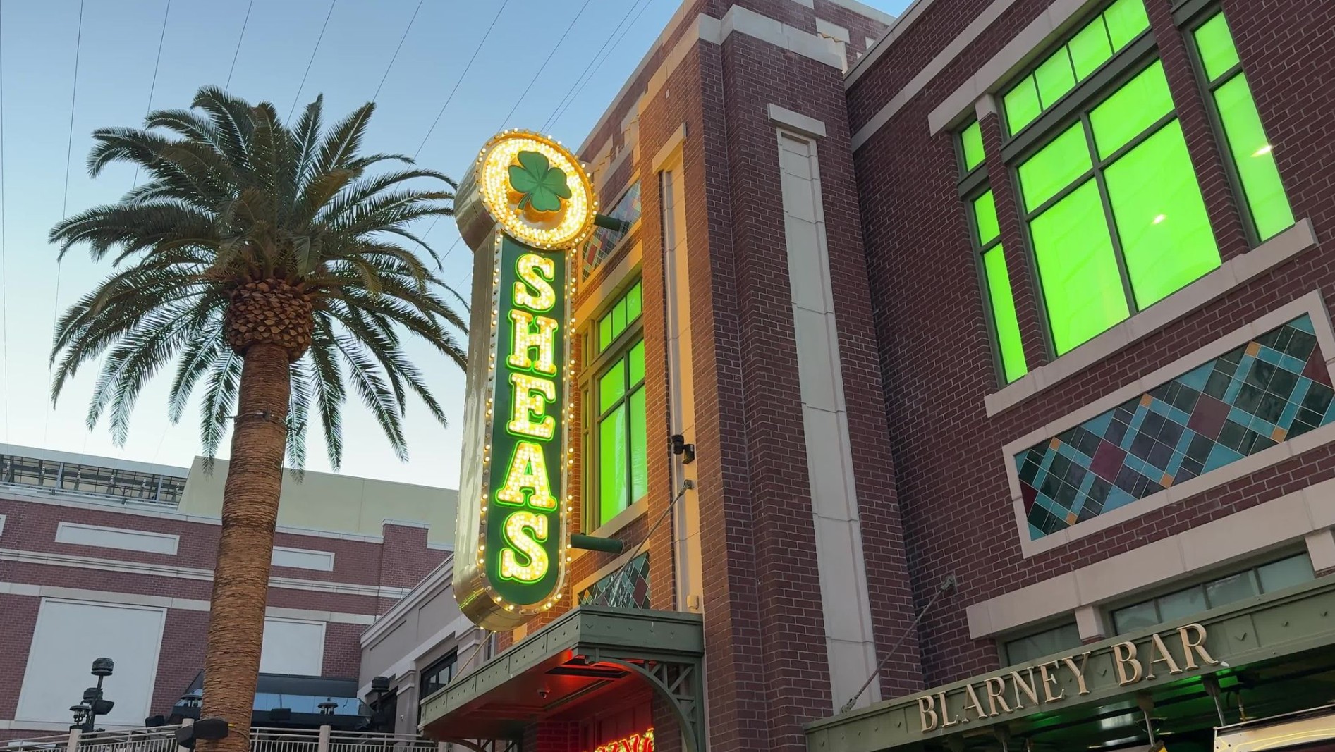 Exterior signing at O'Sheas, lit up at dusk.
