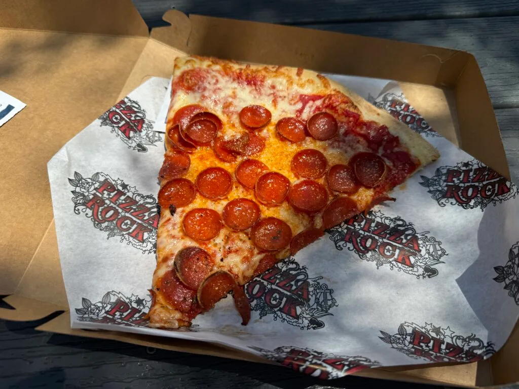 A slice of pepperoni, with 25 pepperonis on it, in a box.
