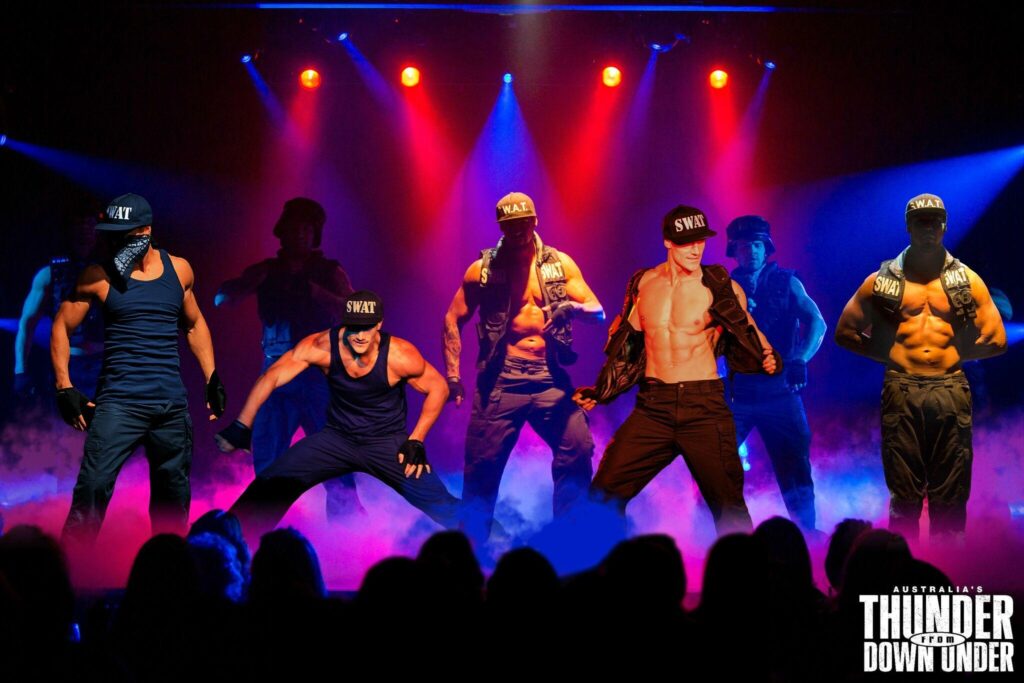 A group of performers on stage dressed like members of a swat team