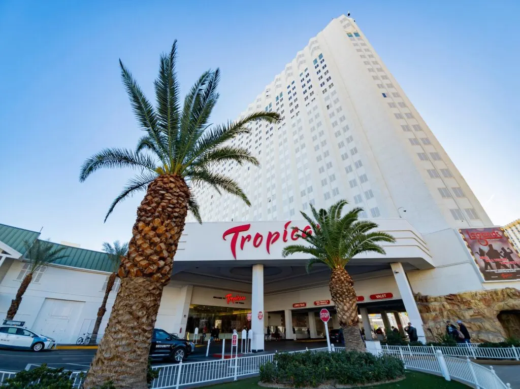 Exterior of Tropicana Las Vegas with 2 palm trees in the foreground.