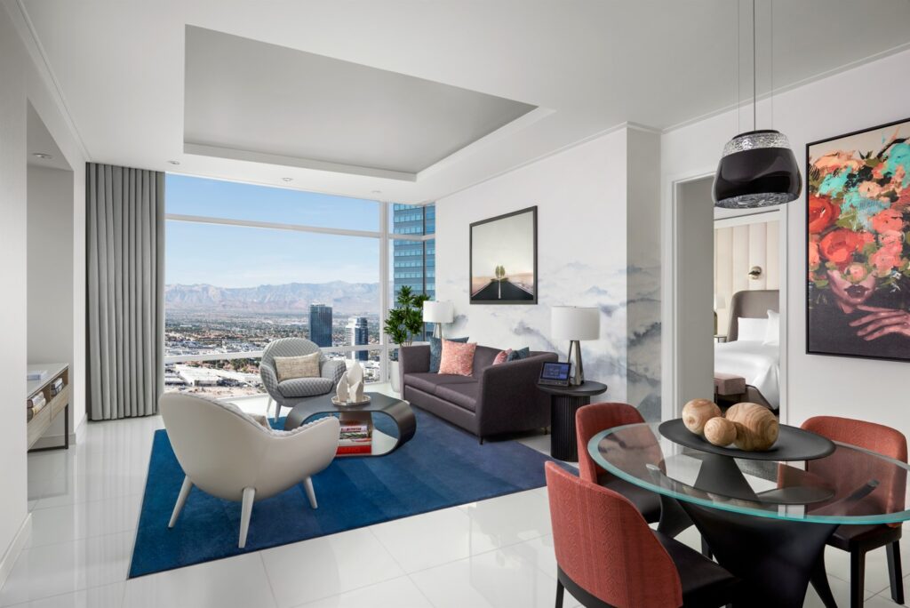 A fashionable living area with seating and floor to ceiling windows in the Sky Suite.