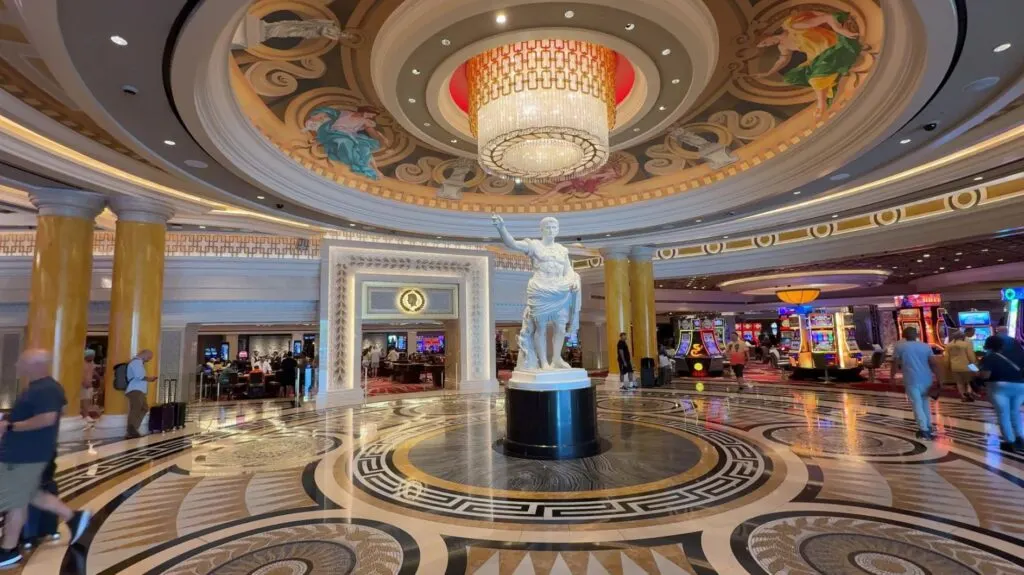 A statue underneath a chandelier in the new entryway.