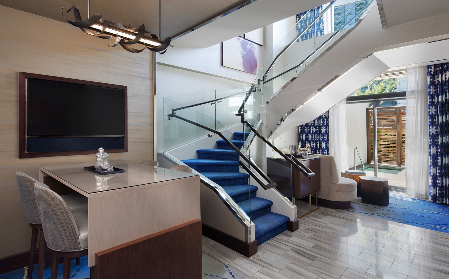 Main level of the Lanai Suite, which shows a glass door in the background that leads out to the dipping pool.