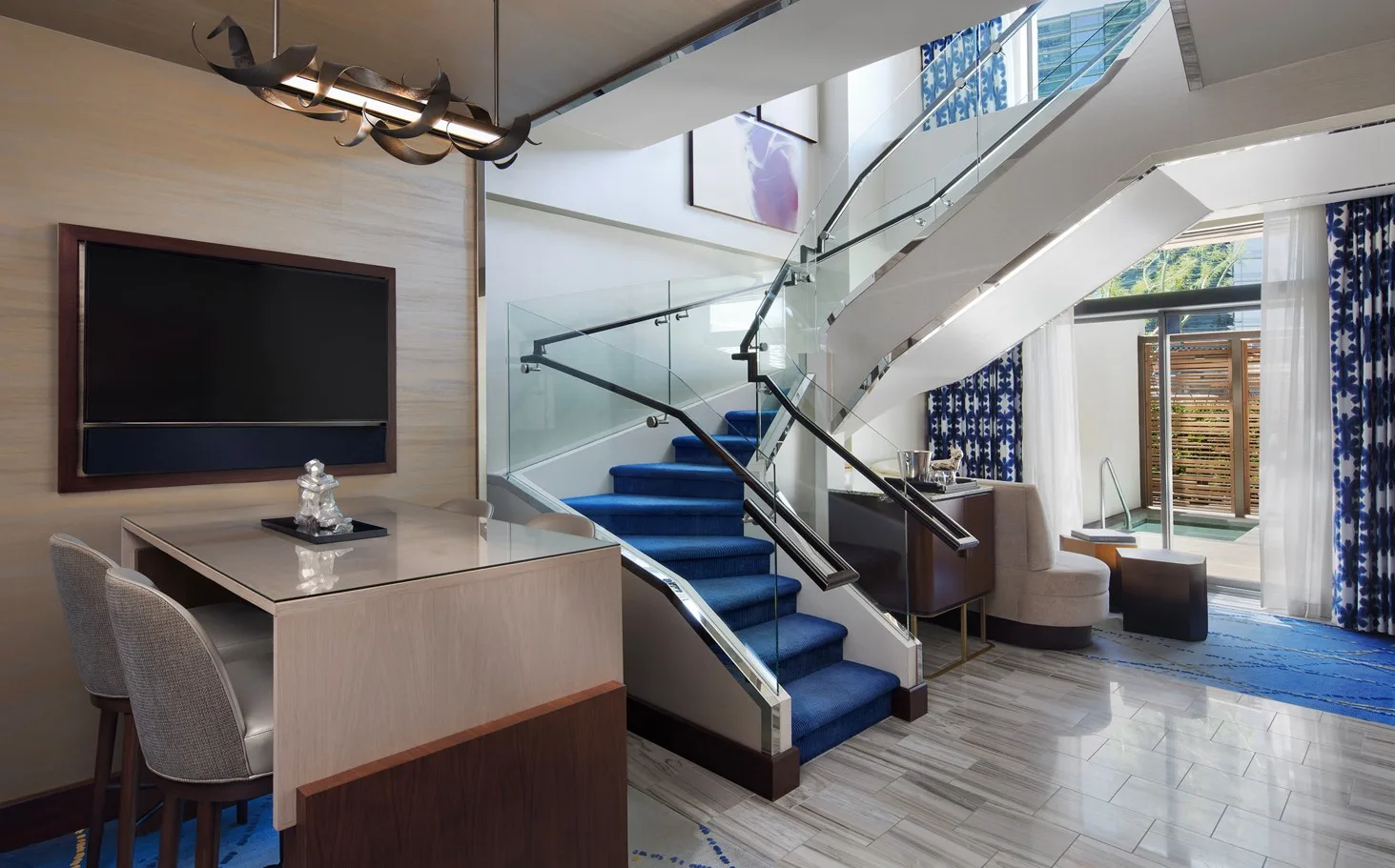 Main level of the Lanai Suite, which shows a glass door in the background that leads out to the dipping pool. 