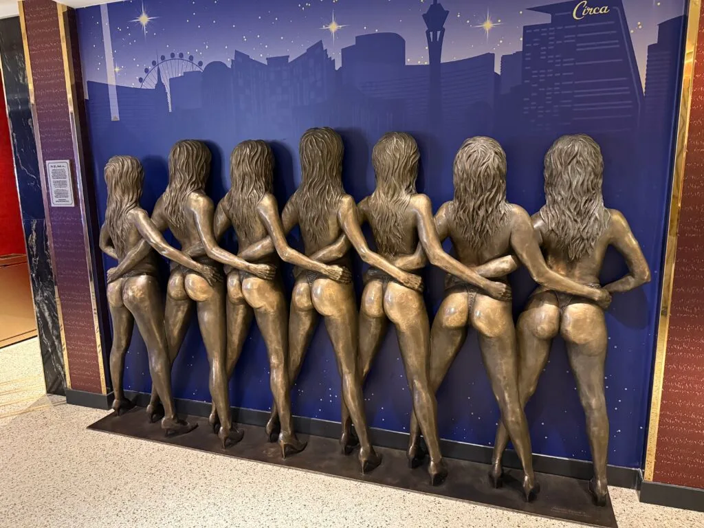 Bronze statue depicting 7 showgirls standing side by side. 