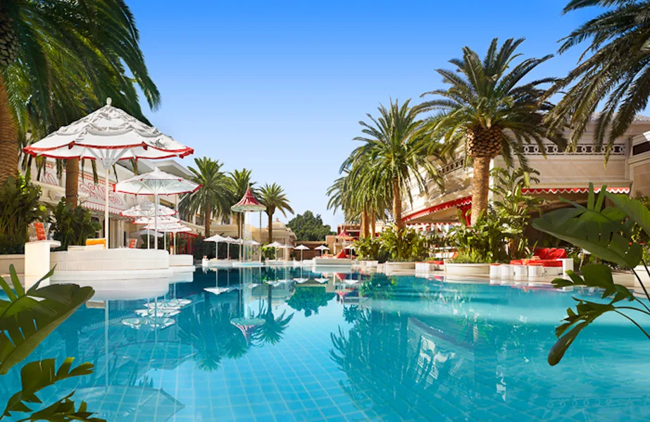 Pool surrounded by palm trees at Encore Beach Club