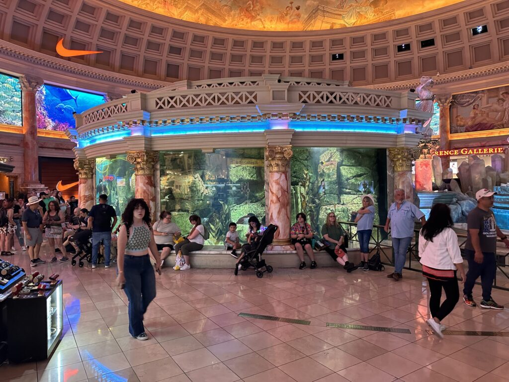 Circular aquarium in the middle of an atrium that is part of the Forum Shops.