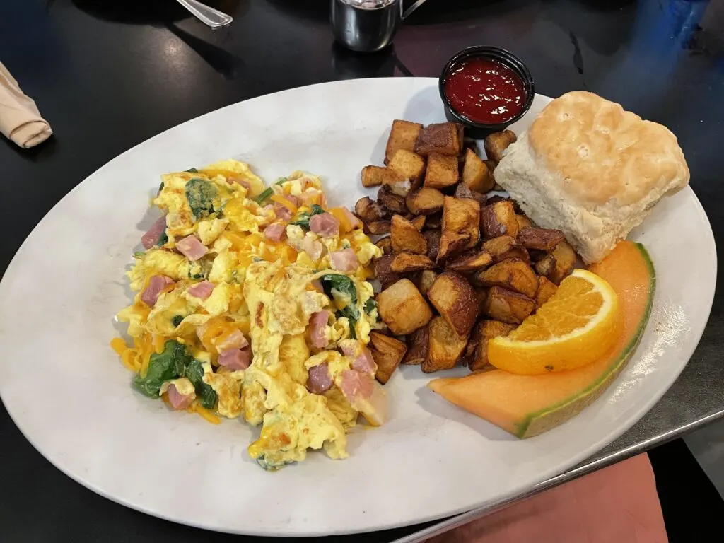 Ham, Egg, and Cheese Scrambler, cubed potatos, a biscuit, and fruit