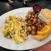 Ham, Egg, and Cheese Scrambler, cubed potatos, a biscuit, and fruit