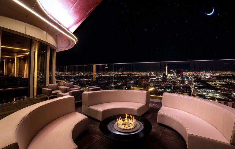 A firepit in Legacy Club's outdoor seating area with a view of the Strip to the south at night.