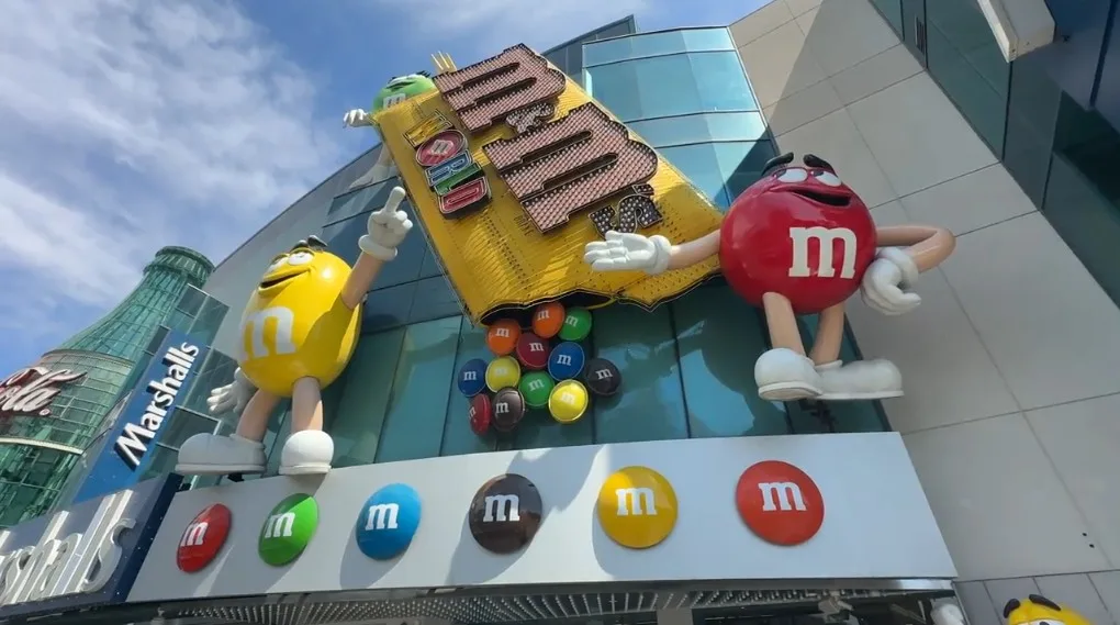 Exterior of M&M's world which has two giant "humanized" M&M's posing next to a bag of peanut M&Ms.