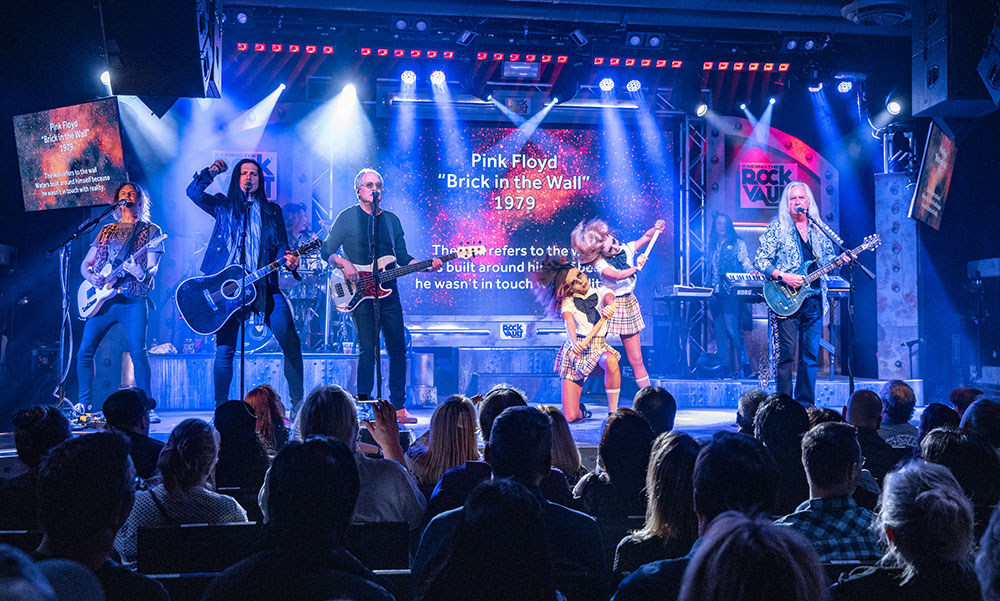 Performers on stage playing Brick in the Wall by Pink Floyd