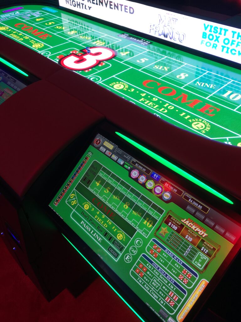 An individual betting terminal with the digital craps table in the background. 