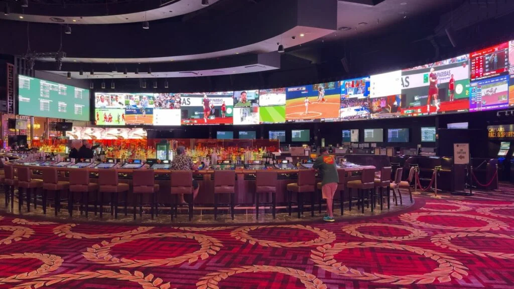 Caesars Palace Sportsbook with a bar in the foreground.