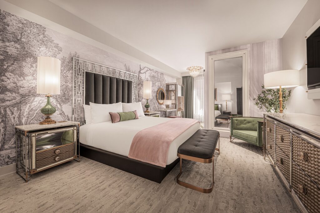 Another angle of the room, which shows the hallway to the bathroom behind the king bed and a floor to ceiling mirror. 