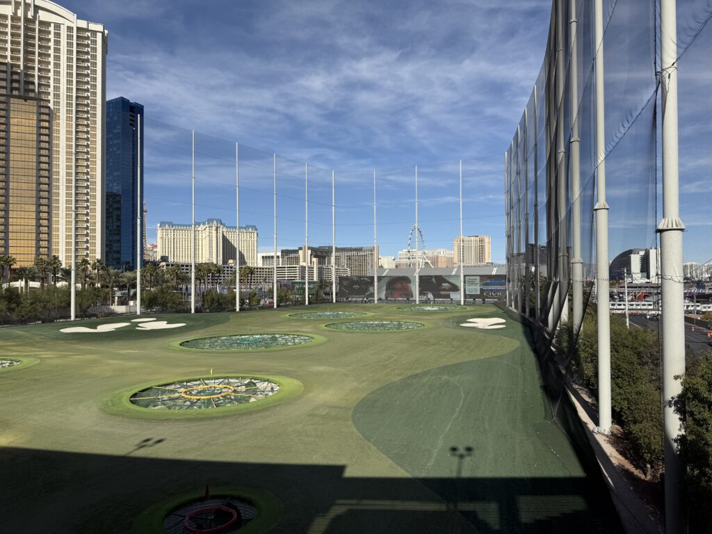The range at Topgolf with giant TV screens at the end of the range.