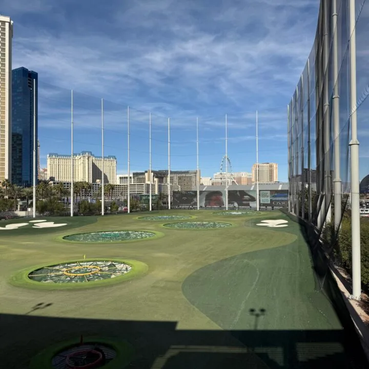 The range at Topgolf with giant TV screens at the end of the range.