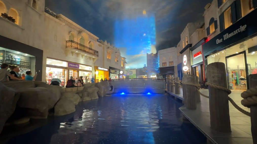 An image is projected on a sheet of water above a pond in the Miracle Mile Shops. 