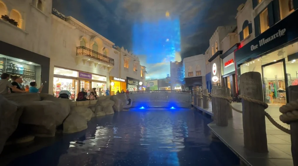 An image is projected on a sheet of water above a pond in the Miracle Mile Shops.
