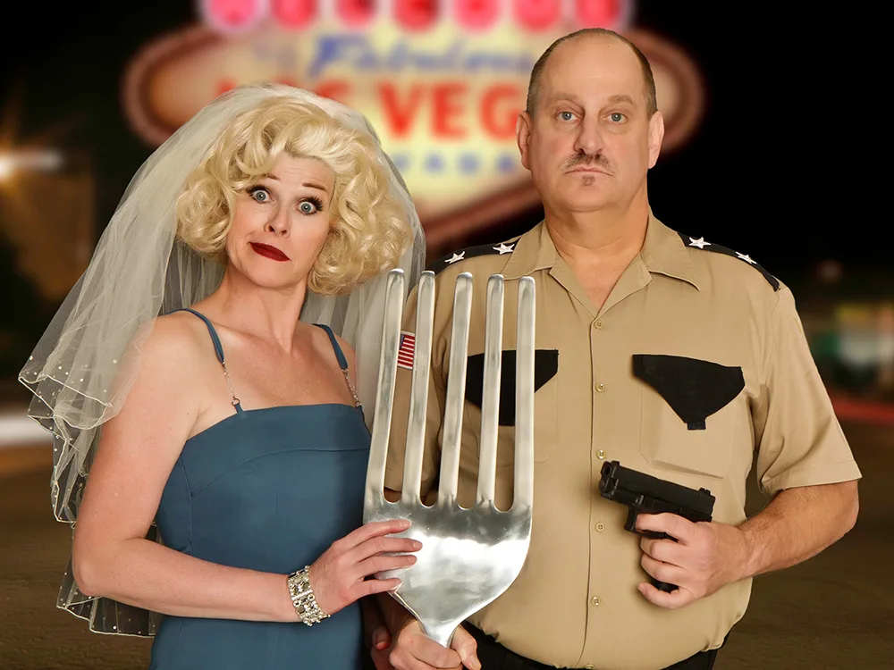 Man and Woman posing with a giant fork between them